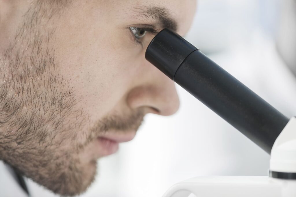 Close up man looking microscope (1) (1)